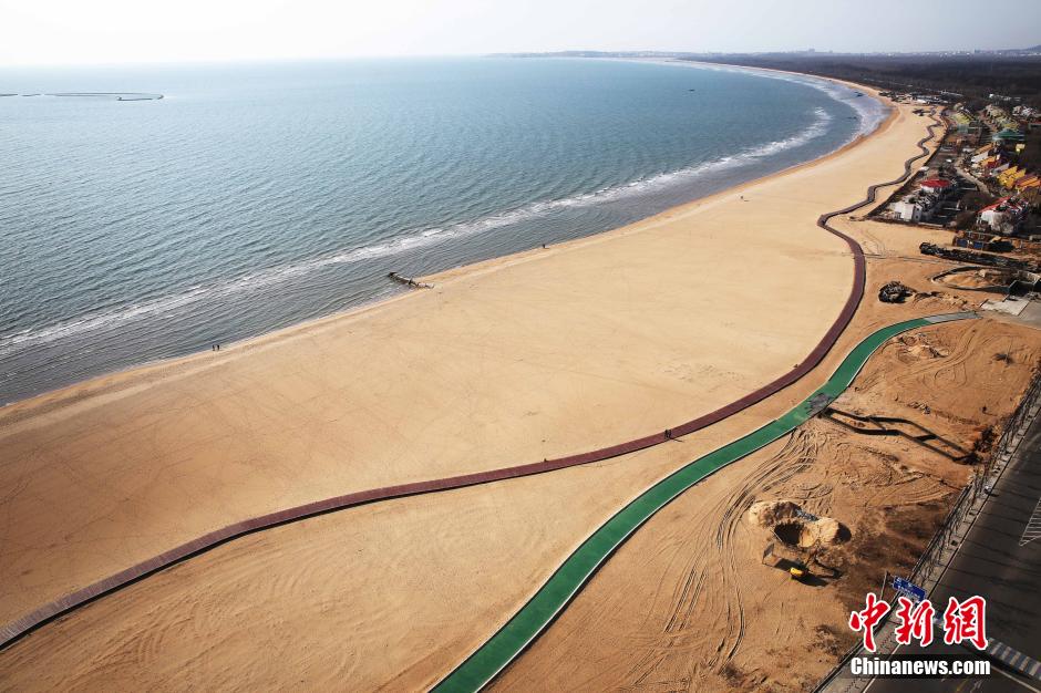 3月13日，秦皇島萬(wàn)米臨海沙灘木棧道。據(jù)了解，該木棧道全長(zhǎng)約4200米，與北戴河區(qū)原有的7500米木棧道對(duì)接后全線總長(zhǎng)度1.17萬(wàn)米，整個(gè)木棧道東起秦皇島體育基地游船碼頭，西至北戴河濕地公園，呈波浪形蜿蜒10.4公里海岸線。 中新社發(fā) 曹建雄 攝 CNSPHOTO